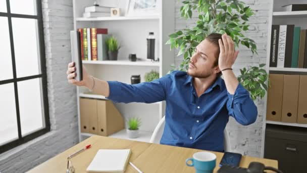 Genç İspanyol iş adamı ofiste gülümseyen dokunmatik kağıt ile selfie çekiyor. - Video, Çekim