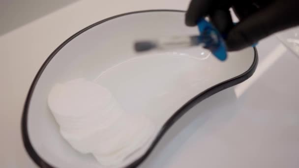 Una mano en un guante protector coloca una jeringa en un recipiente de hierro medicinal - Metraje, vídeo