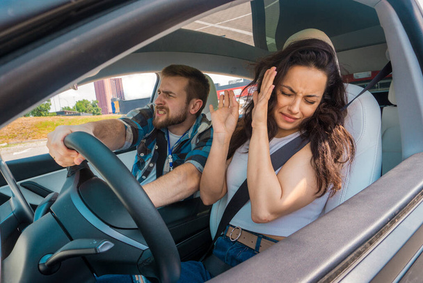 Εκπληκτική εκπαιδευτής κάθεται στο αυτοκίνητο και κοιτάζει ευθεία μπροστά, ενώ η κυρία κλείνει τα μάτια της και ουρλιάζει. Τροχαίο ατύχημα. Δοκιμή οδήγησης, μαθήματα οδήγησης, εξεταστική έννοια - Φωτογραφία, εικόνα