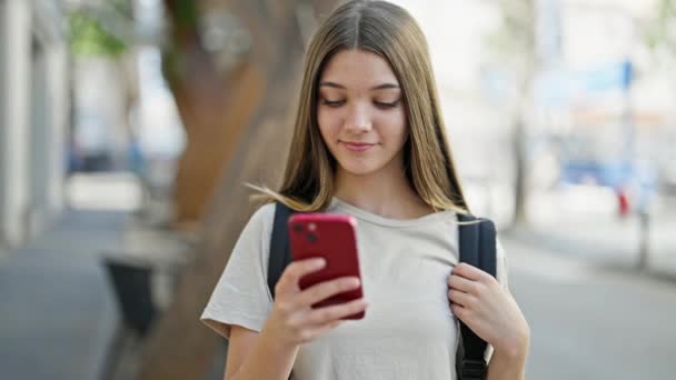 jong mooi meisje student dragen rugzak met behulp van smartphone op straat - Video