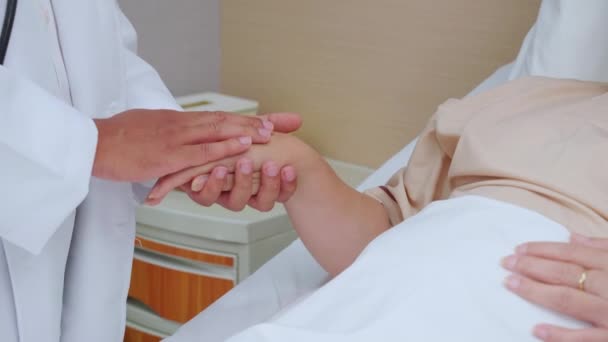 Nauwe handen van de arts man aan te moedigen met oudere patiënt in het ziekenhuis, arts verzorgen en hand in hand voor het troosten van senior ziek, diagnostische ziekte en ziekte, medisch concept. - Video