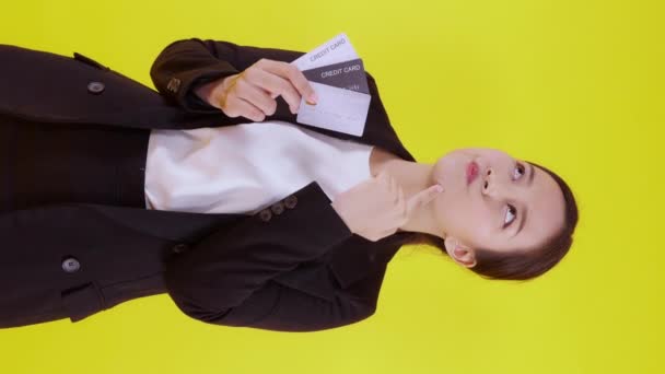 Портрет красивая молодая азиатская бизнес-женщина держать кредитную карту или дебетовую карту для покупки оплаты и сделки с финансовым на желтом фоне, предпринимательница показывает банкомат, финансовая концепция. - Кадры, видео