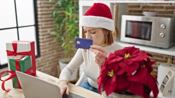 Молодая блондинка с ноутбуком и кредитной картой празднует Рождество выглядит расстроенным в столовой - Кадры, видео