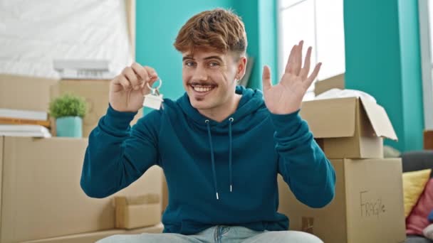 Mladý hispánec se usmívá sebevědomě drží nové klíče od domu v novém domově - Záběry, video