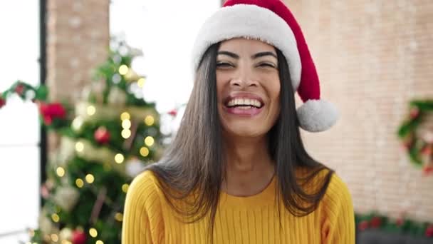 Νεαρή όμορφη ισπανόφωνη γυναίκα χαμογελά σίγουρος γιορτάζει τα Χριστούγεννα στο σπίτι - Πλάνα, βίντεο