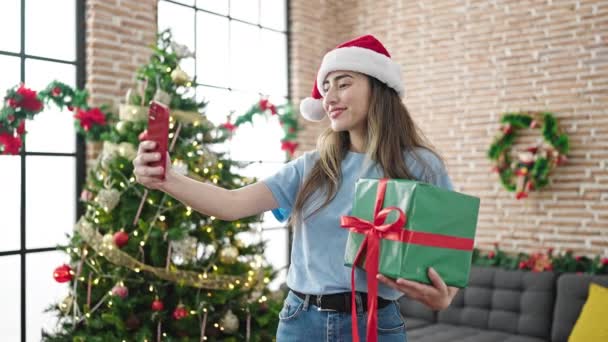 Genç ve güzel İspanyol kadın, akıllı telefonuyla Noel 'i evde kutlarken selfie çekiyor. - Video, Çekim