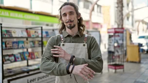 Jonge Spaanse ober glimlachend zelfverzekerd staand met armen gekruist gebaar op terras van de coffeeshop - Video