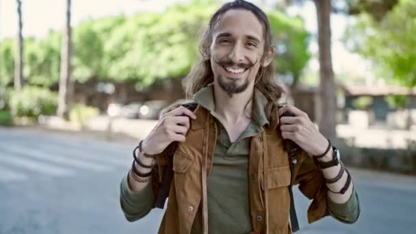 Молодой латиноамериканец в рюкзаке улыбается в парке - Кадры, видео