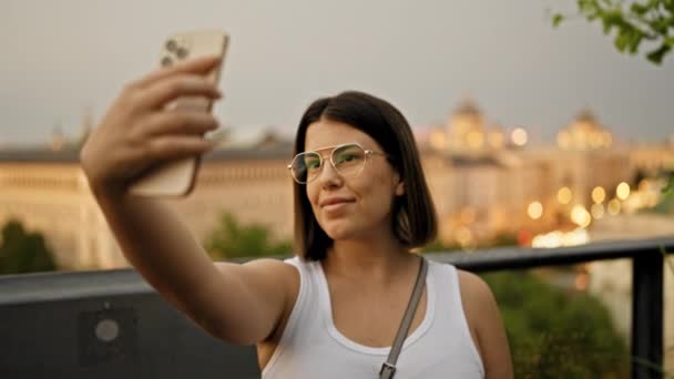 Νεαρή όμορφη ισπανόφωνη γυναίκα που παίρνει selfie με smartphone στην ταράτσα του μπαρ - Πλάνα, βίντεο