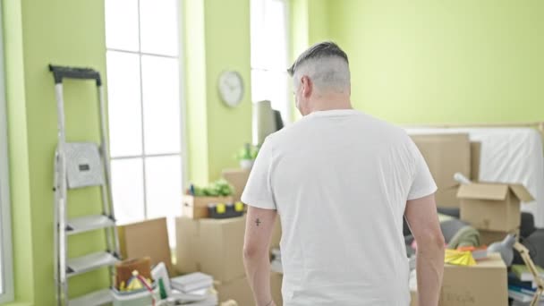 Nuori valkoihoinen mies hymyilee itsevarma seisoo kädet auki uudessa kodissa - Materiaali, video