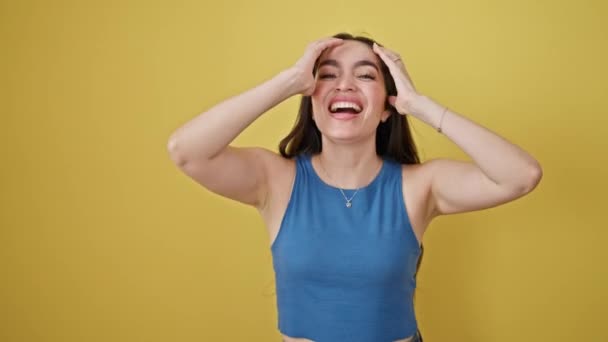 Giovane bella donna ispanica sorridente fiducioso gridando su isolato sfondo giallo - Filmati, video