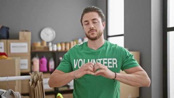 Νεαρός Ισπανός εθελοντής χαμογελώντας με αυτοπεποίθηση κάνει χειρονομία καρδιάς στο φιλανθρωπικό κέντρο - Πλάνα, βίντεο