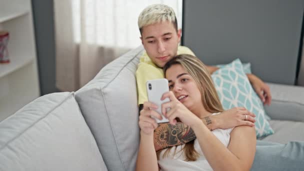 Όμορφο ζευγάρι που χρησιμοποιεί smartphone γιορτάζει στο σπίτι - Πλάνα, βίντεο