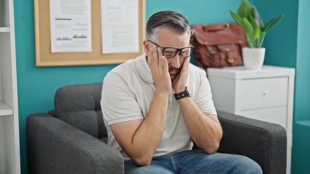 オフィスでストレスを受けたメガネを取る灰色の髪の男のビジネスワーカー - 映像、動画
