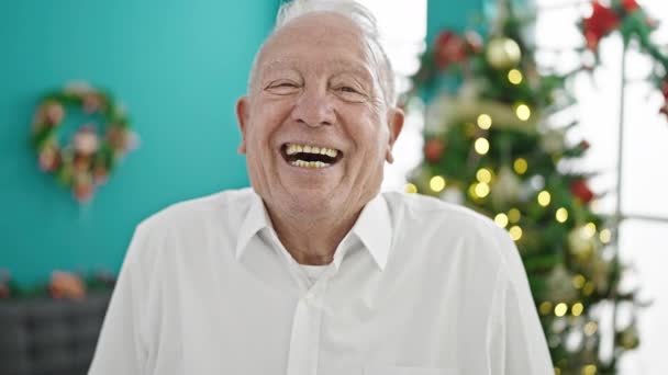 Senior harmaa tukka mies hymyilee juhlii joulua kotona - Materiaali, video
