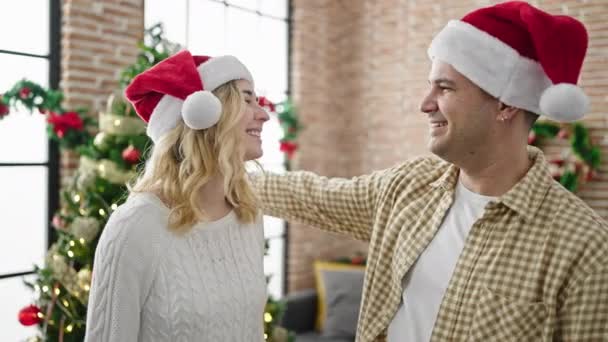 Άνδρας και γυναίκα ζευγάρι αγκαλιάζονται γιορτάζοντας τα Χριστούγεννα στο σπίτι - Πλάνα, βίντεο