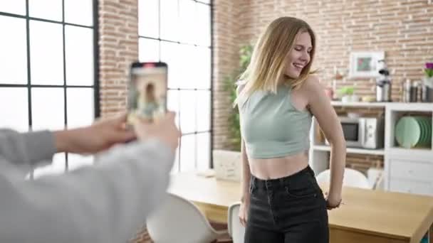 Nuori blondi nainen hymyilee luottavainen tallennus video tanssia ruokasalissa - Materiaali, video