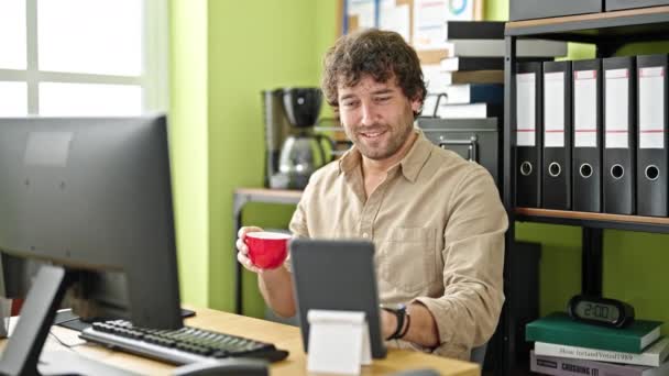 若いヒスパニック男性ビジネスワーカーは,オフィスでタッチパッドとコンピュータ飲料コーヒーを使用しています - 映像、動画