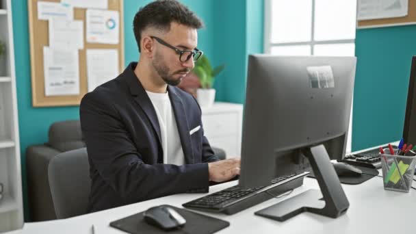 Fiatal arab férfi üzletember számítógéppel jegyzetel az irodában - Felvétel, videó
