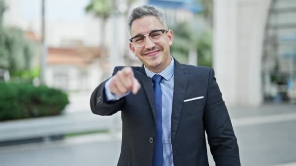 Jonge Spaanse man zakenman lachend vol vertrouwen komt gebaar maken op straat - Video