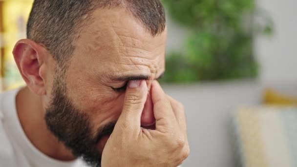 Jeune homme hispanique pleurant assis sur le canapé à la maison - Séquence, vidéo