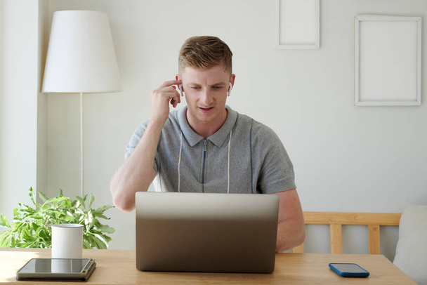 Portret młodego biznesmena noszącego słuchawki podczas rozmowy wideo - Zdjęcie, obraz