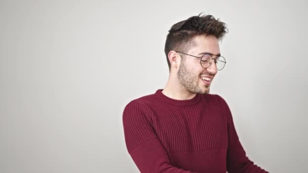 Jonge Spaanse man glimlachend wijzend naar de zijkant over geïsoleerde witte achtergrond - Video