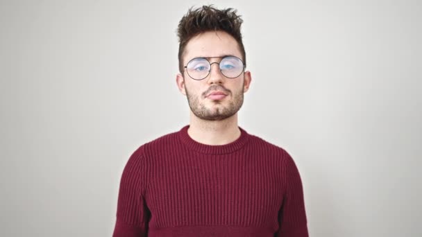 Jeune homme hispanique souriant confiant tenant passeport sur fond blanc isolé - Séquence, vidéo