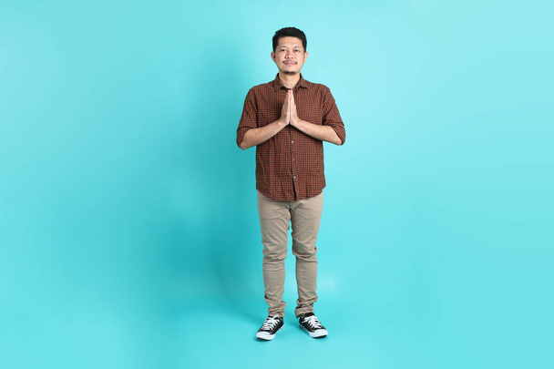 The adult Asian man in smart casual clothes standing on the green background background. - Фото, изображение
