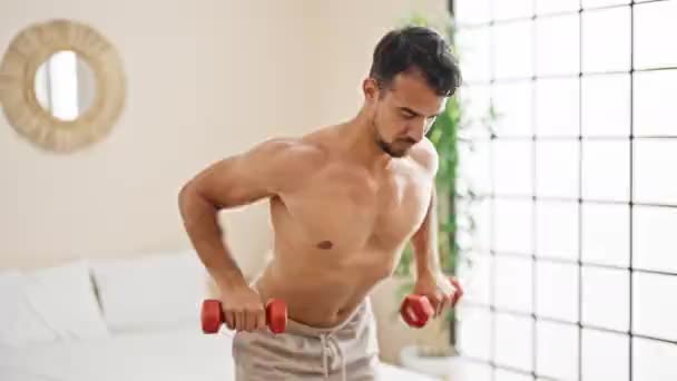 Mladý hispánec muž trénink zpět s činkami v ložnici - Záběry, video