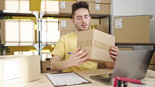 Fiatal spanyol férfi e-kereskedelmi üzletember ellenőrzi csomagok írás vágólapon az irodában - Felvétel, videó