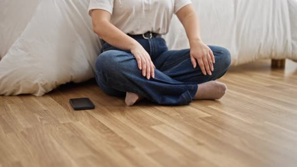 Mujer hispana hermosa joven haciendo ejercicio de yoga sentado en el suelo en el dormitorio - Imágenes, Vídeo
