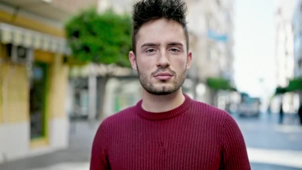 Νεαρός Ισπανός στέκεται με σοβαρή έκφραση στο δρόμο - Πλάνα, βίντεο