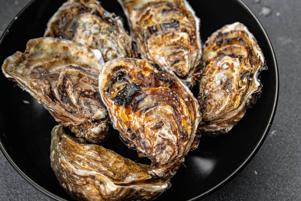 osztrigahéj friss tenger gyümölcsei kagyló osztriga liszt snack az asztalon másolni tér élelmiszer háttér rusztikus felső nézet - Fotó, kép