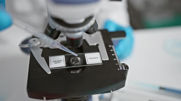 Вчений середнього віку використовує мікроскоп в лабораторії - Кадри, відео