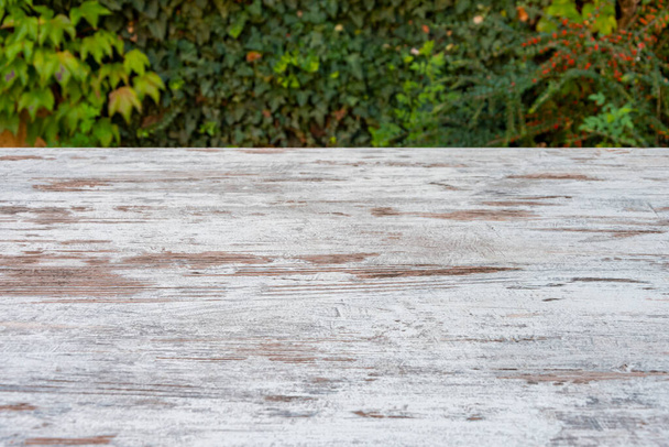 Surface de table en bois contre les feuilles de raisin vert, panneaux en bois vieilli et texturé, ressource graphique, espace pour votre texte, espace de copie. - Photo, image
