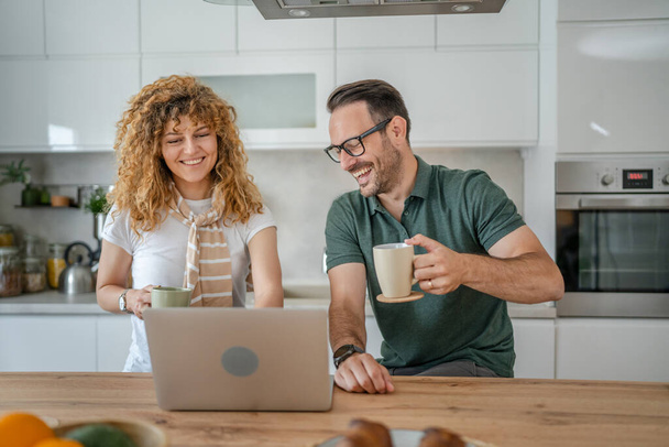 ευτυχισμένο ζευγάρι καυκάσιος ενήλικας άνδρας και γυναίκα σύζυγος και γυναίκα πρωί ρουτίνα χρήση φορητού υπολογιστή κατά τη διάρκεια του πρωινού στο σπίτι φωτεινό φωτοαντίγραφο χώρου - Φωτογραφία, εικόνα