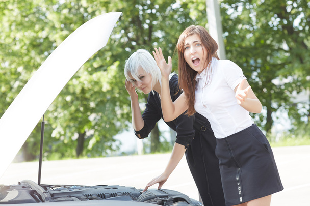 Young women near broken car  - Valokuva, kuva