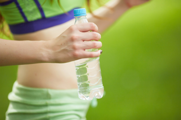 sportswoman with bottle of water - Foto, afbeelding