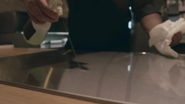 Detailní záběr rukou nerozpoznatelného šéfkuchaře v uniformě a úklidu zástěry v kuchyni restaurace na konci směny, stříkací pult s dezinfekční kapalinou a otírání bílou látkou - Záběry, video