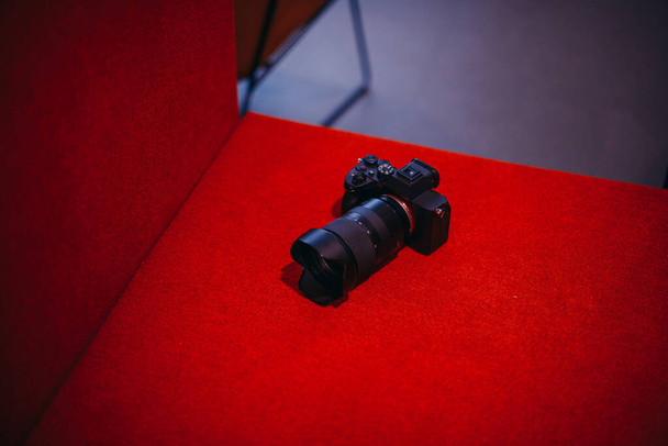 Φωτογραφία φωτογραφικής μηχανής τοποθετημένης σε κόκκινο φόντο καναπέ - Φωτογραφία, εικόνα