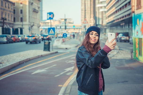 Beautiful girl taking a selfie in the city streets - Фото, зображення