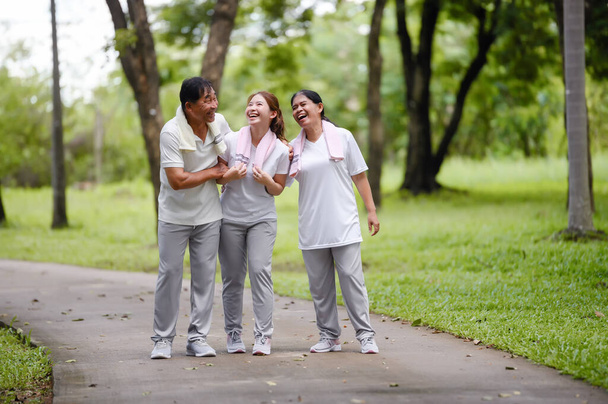 Happy Asian Family Pokazywanie sobie nawzajem miłość i troska w parku podczas Walking for Exercise. Więzi rodzinne bez granic, Tworzenie szczęścia rodzinnego na świeżym powietrzu. - Zdjęcie, obraz