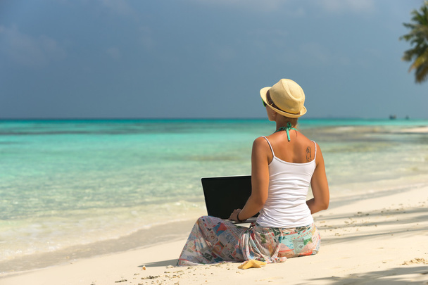 Mujer en la playa tropical exótica con ordenador portátil
 - Foto, Imagen