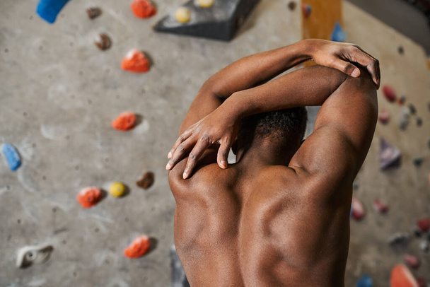 Atletik formda Afro-Amerikan bir adamın elleri başının arkasında üstsüz poz verişi. - Fotoğraf, Görsel