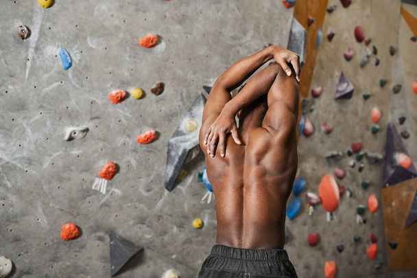Rückenansicht eines fitten afrikanisch-amerikanischen Mannes mit abgewinkeltem Hemd und angespannten Muskeln - Foto, Bild