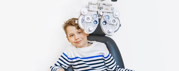 szkolne dziecko robiące test wzroku w klinice - Zdjęcie, obraz