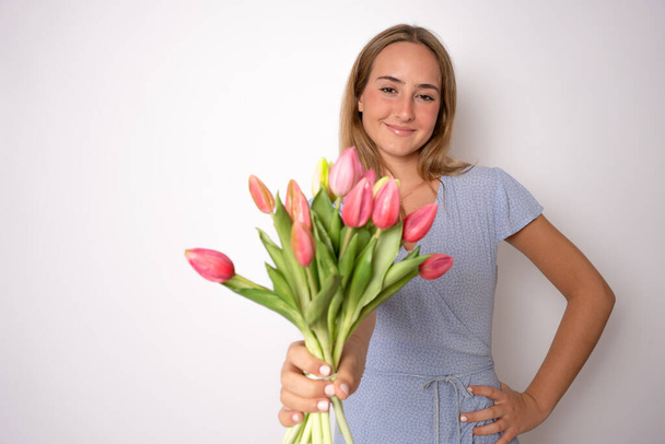 Ritratto di bella ragazza carina allegra che tiene in mano fiori rosa isolati su sfondo bianco - Foto, immagini