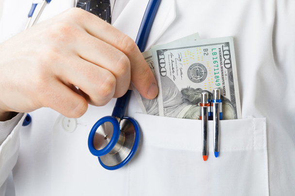 Doctor en medicina con nosotros dólares en su bolsillo - estudio tiro - Foto, imagen