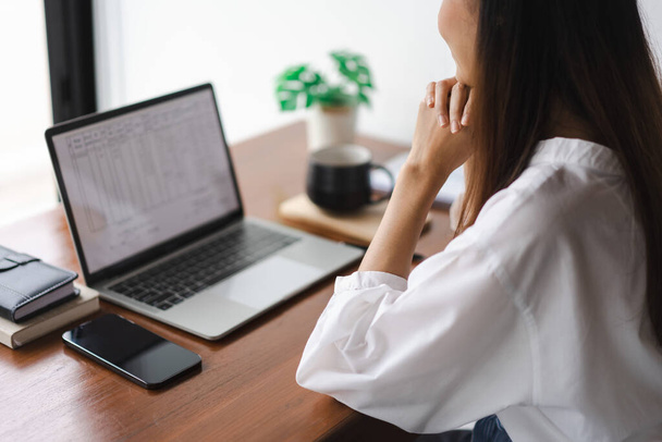 Las mujeres de negocios que leen datos en el ordenador portátil para pensar en la nueva puesta en marcha mientras trabajan en la oficina exterior. - Foto, imagen